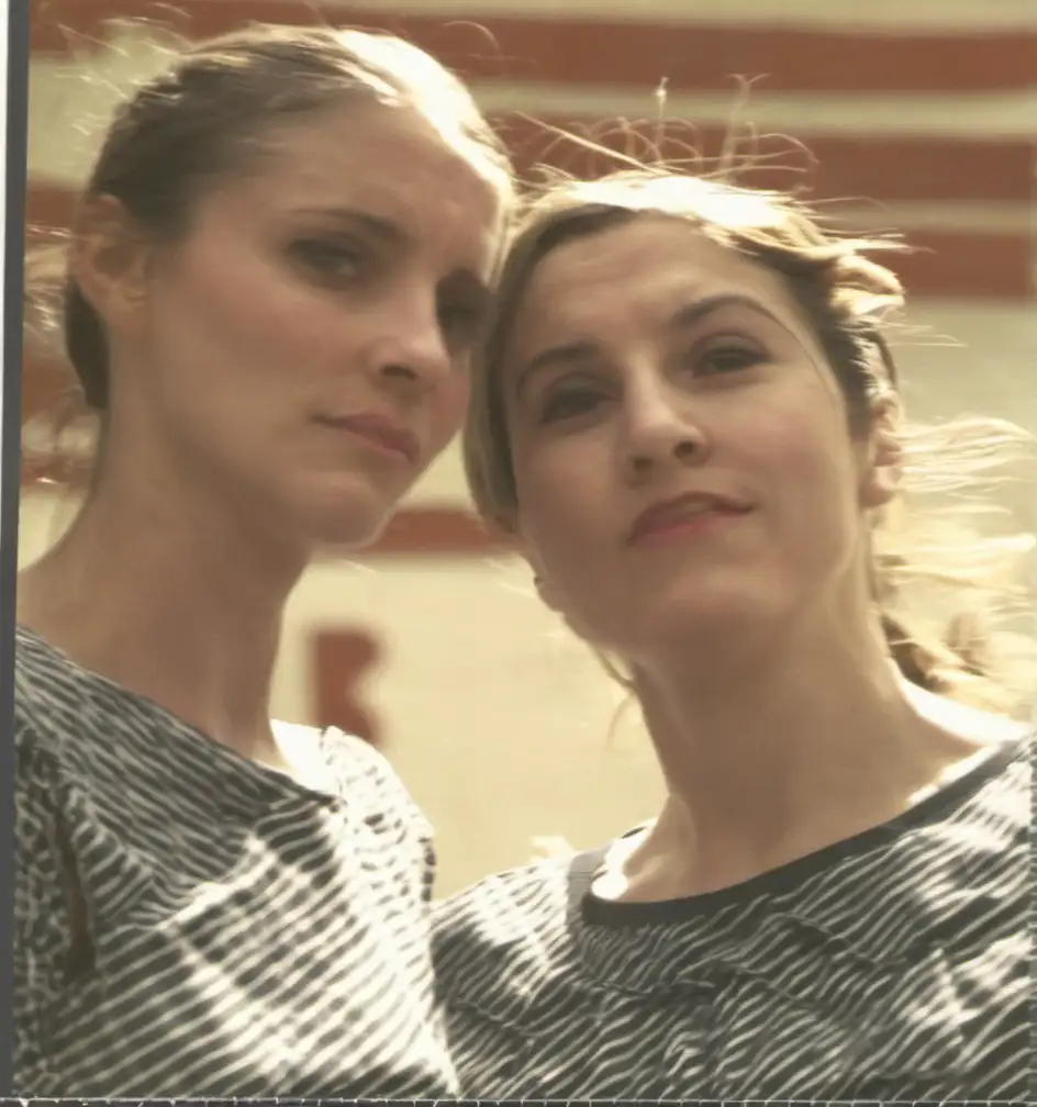 Two Women Gazing Intently at the Camera in Captivating Portrait