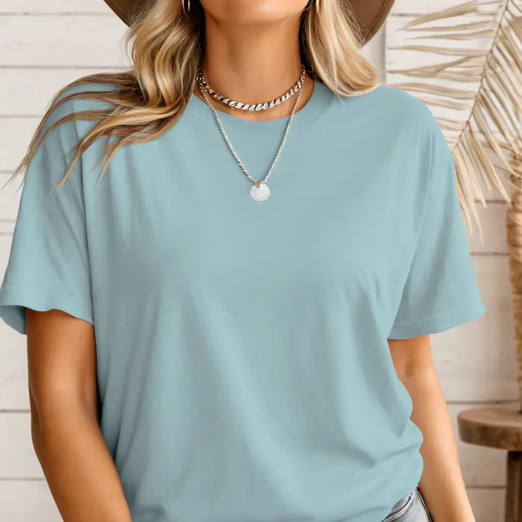 blonde woman wearing bella canvas 3001 dusty blue t-shirt mockup, with cowgirl hat and silver necklace, simple boho home background, body facing front