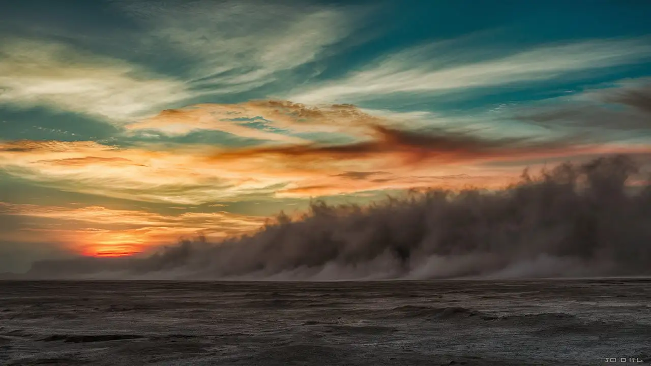 Fiery Sunset Over Barren Wasteland with Teal Orange and Pink Sky